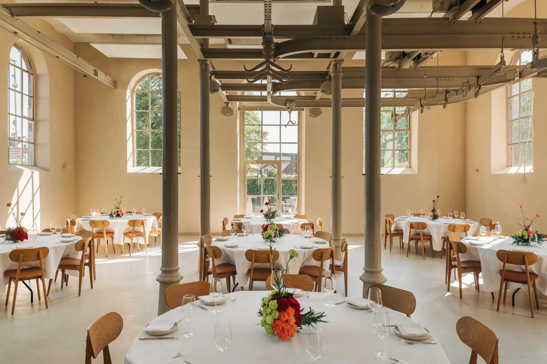 Das helle Loft im l’ab Wiesloch mit Gusssäulen, Bogenfenstern und runden Tafeln